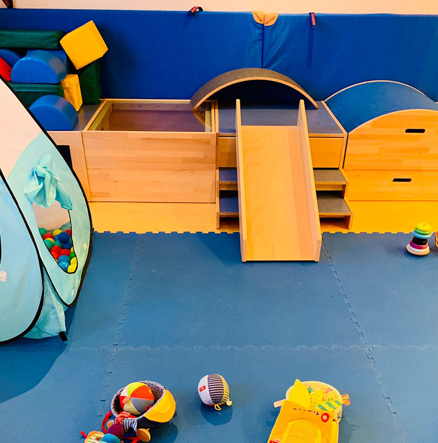 Spielraum mit blauer Matte, Rutsche, Bälle-Zelt und Spielsachen