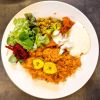Buntes Reisgericht mit Kochbananen, Gemüse und Salat